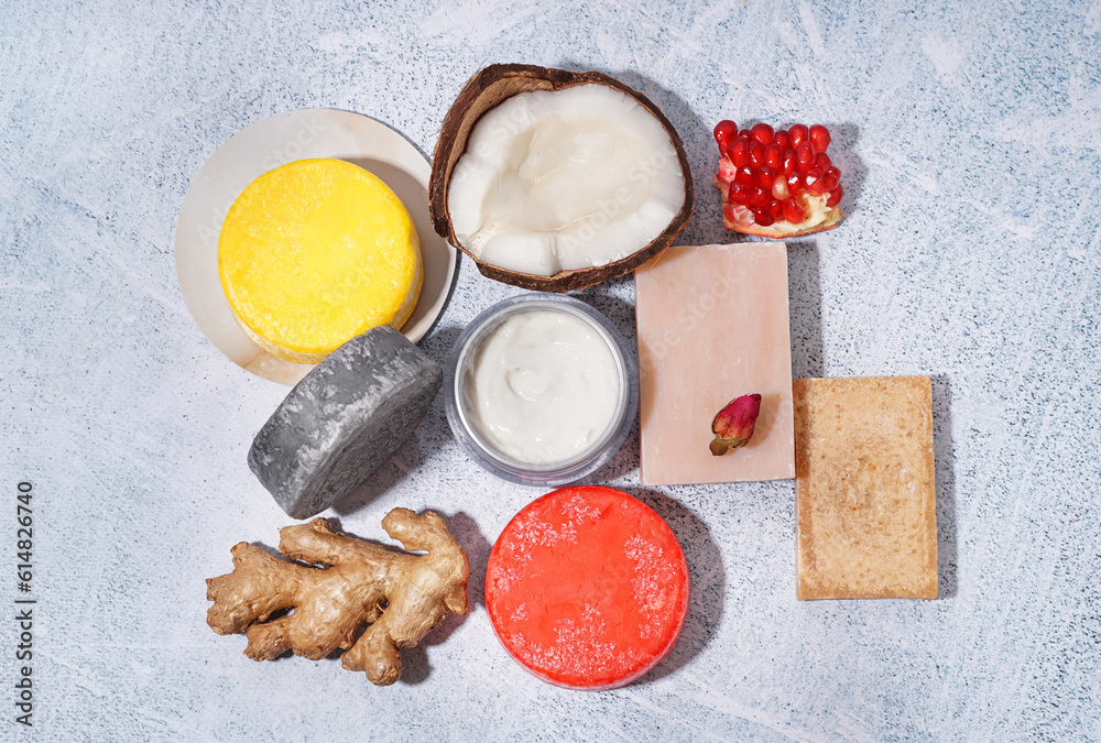 Different handmade solid shampoo, fruits and cream on light background