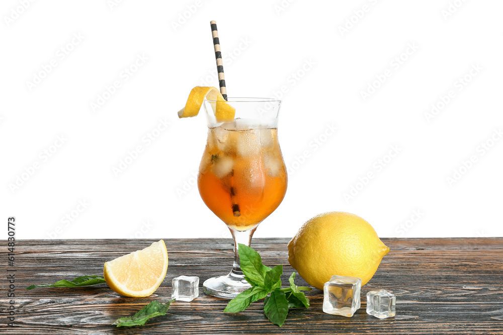 Glass of ice tea with lemon and mint on wooden table against white background