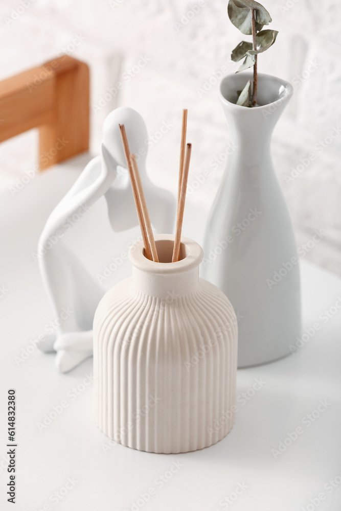 Bottle of reed diffuser and decor on table, closeup