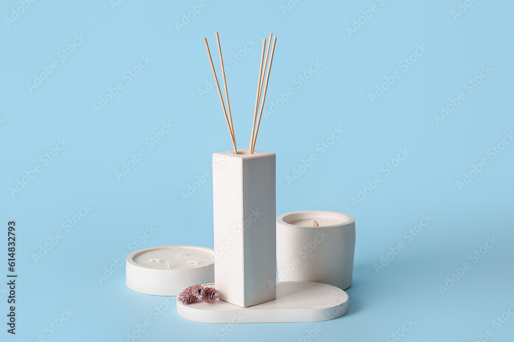 Reed diffuser with candles on blue background