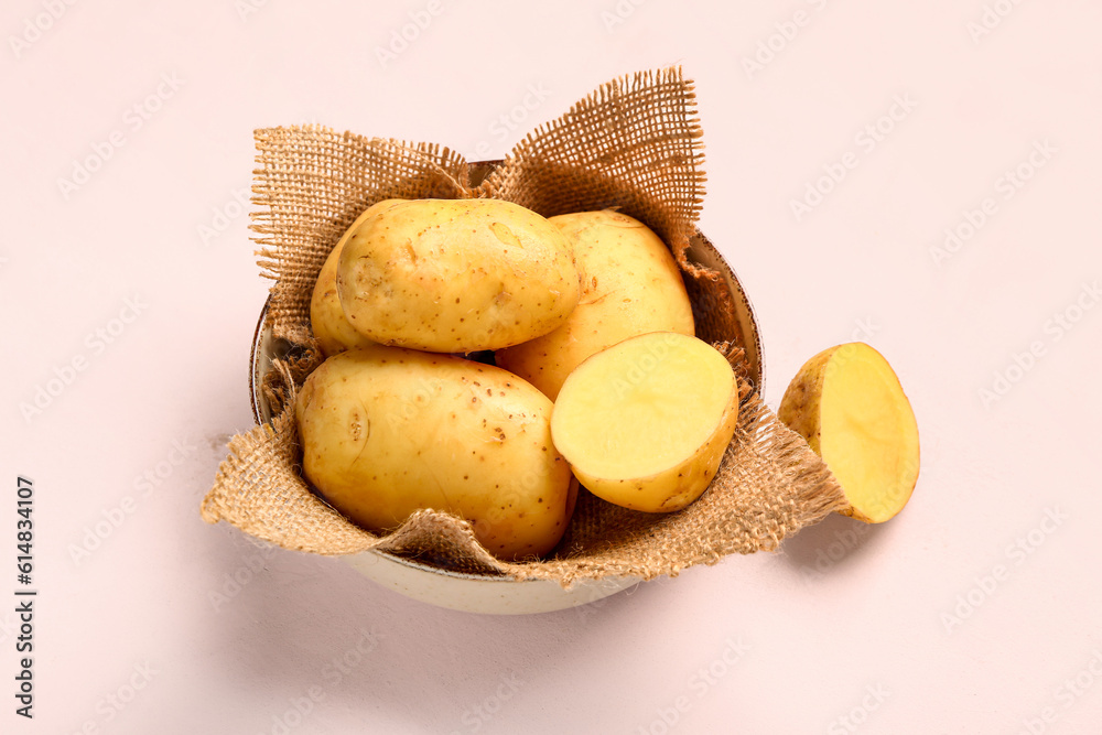 Bowl with raw baby potatoes on white background