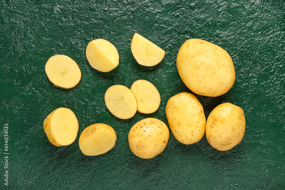 Slices of raw baby potatoes on green background