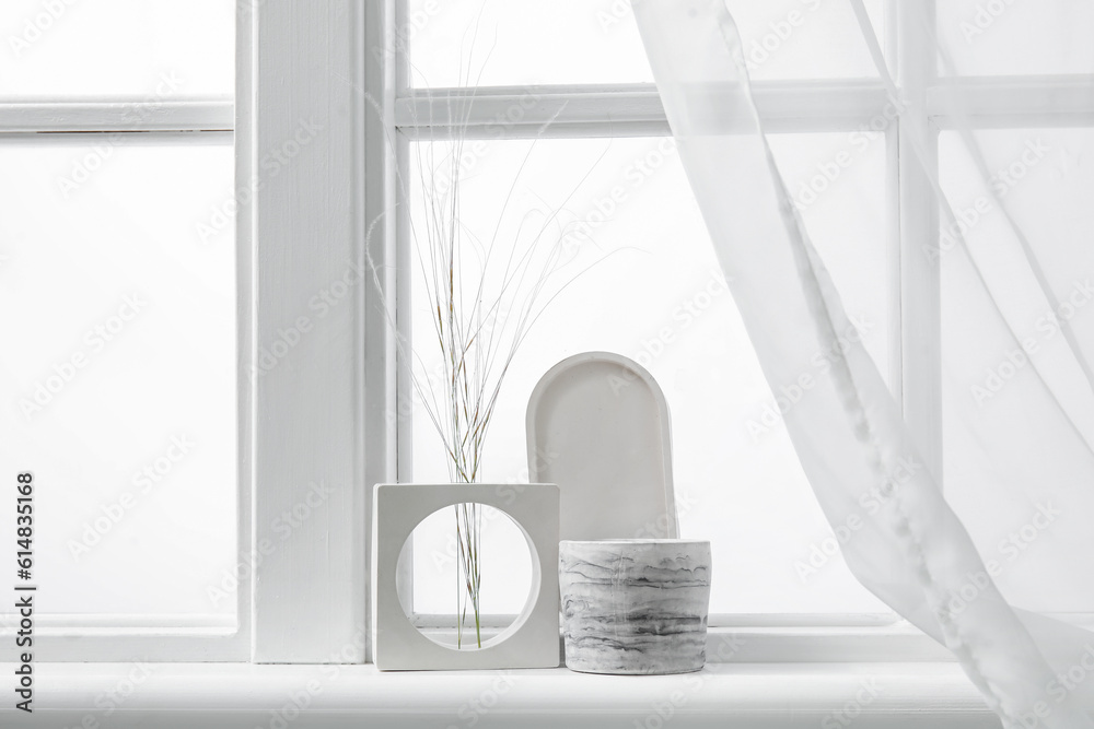 Holder with candle and decor on windowsill in room