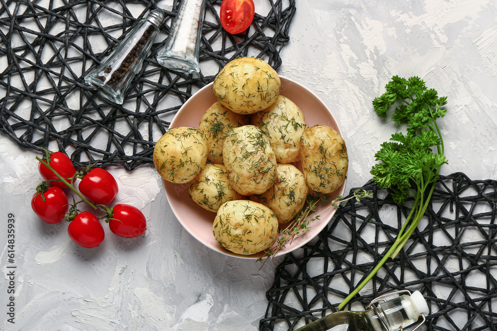 Bowl of boiled baby potatoes with dill and tomatoes on grey background