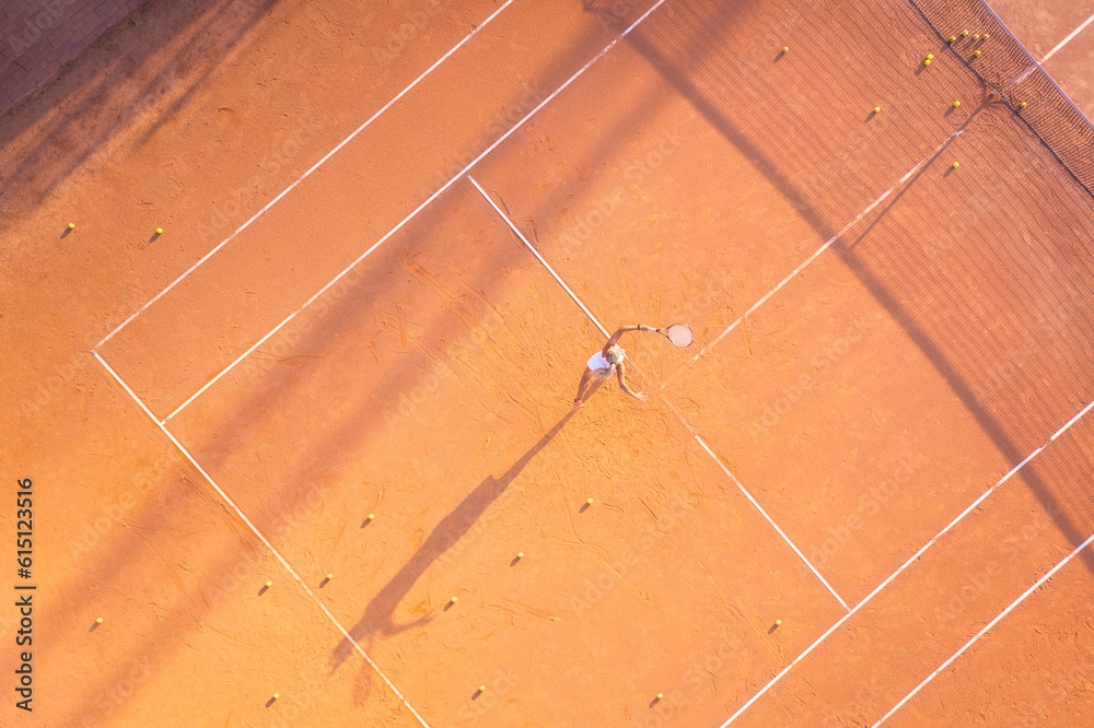 Healthy lifestyle. A young girl plays tennis on the court. The view from the air on the tennis playe