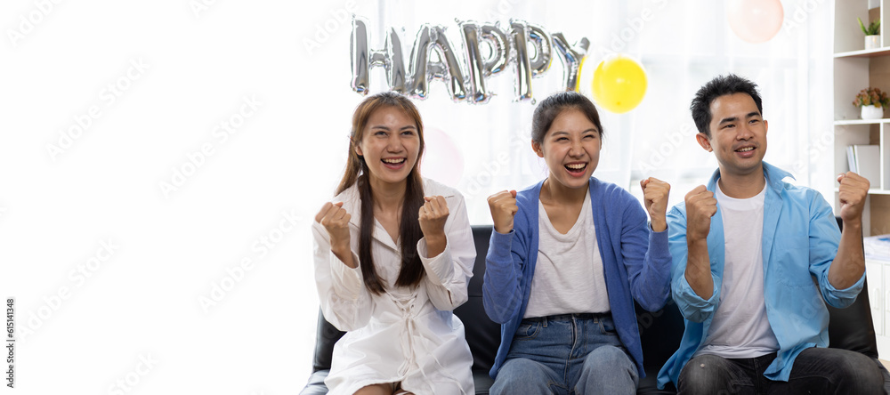 Group of friends cheering for a ball while watching television at a birthday party at home.