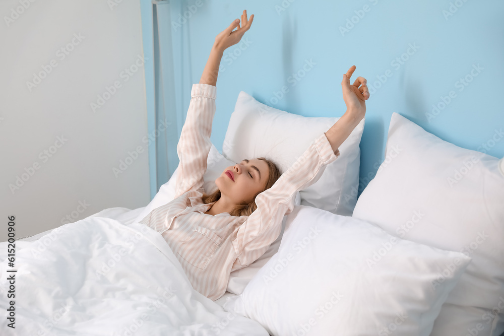 Morning of young woman waking up in bed at home