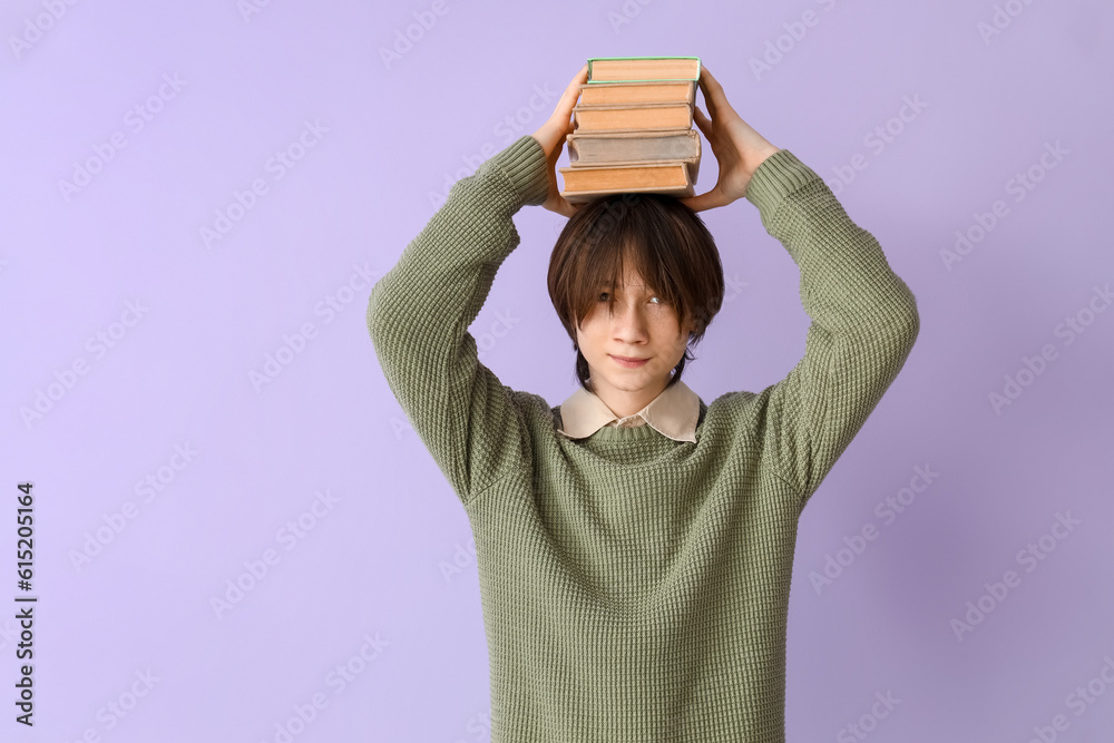 Teenage boy with books on lilac background