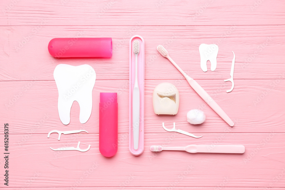 Composition with dental floss, toothpicks and brushes on pink wooden background