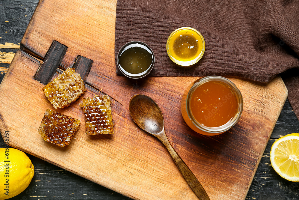 Jar with sweet honey and combs on dark wooden background