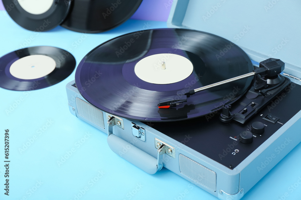 Record player with vinyl disk on blue table, closeup