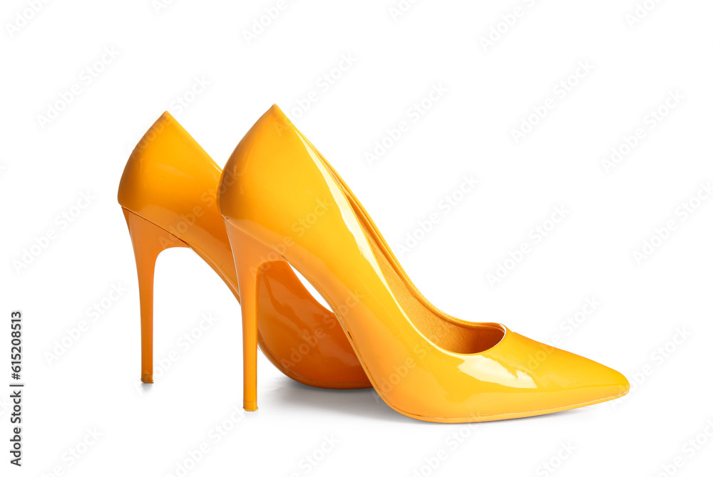 Pair of yellow high heeled shoes on white background