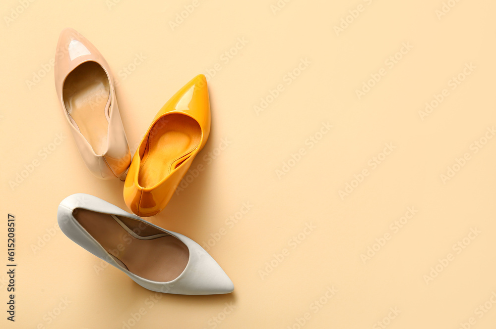 Fashionable high heeled shoes on beige background