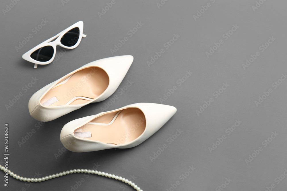 Stylish high heeled shoes and accessories on grey background