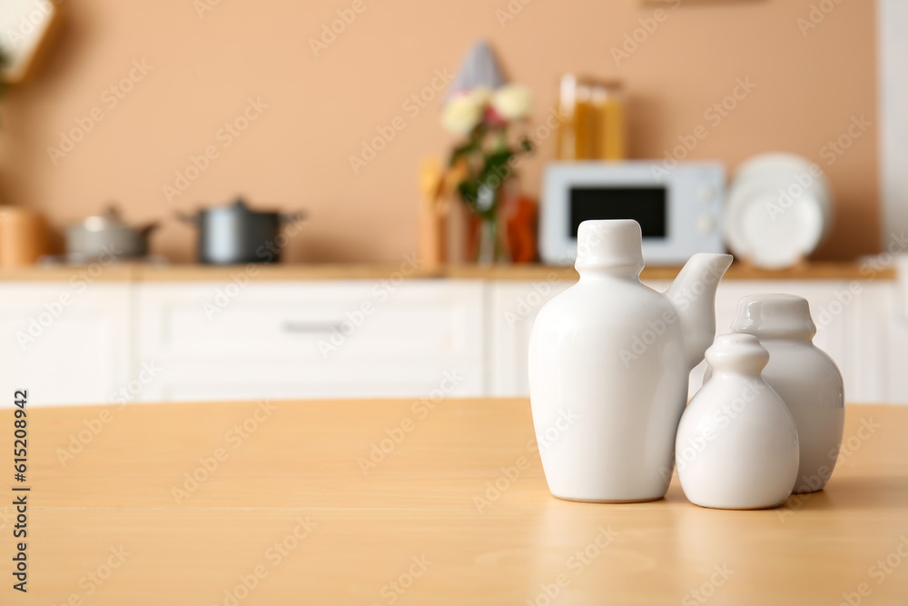 Different porcelain dishes on wooden table in kitchen