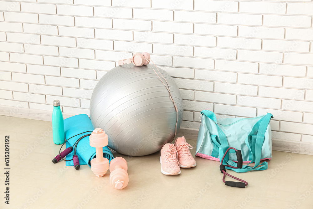 Sports equipment with bag near white brick wall