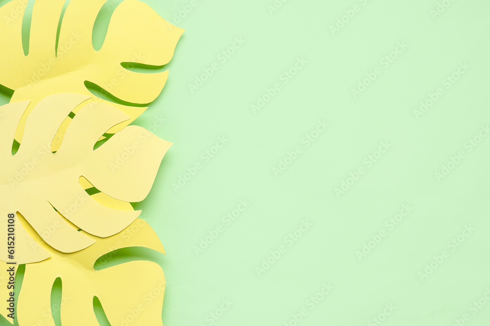 Yellow paper tropical leaves on green background