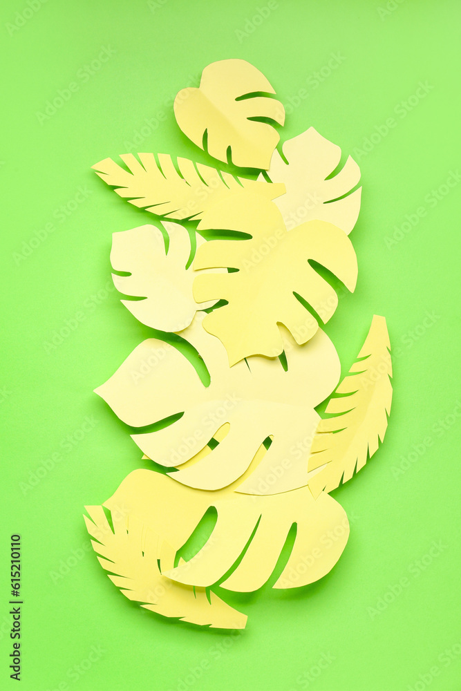 Yellow paper tropical leaves on green background