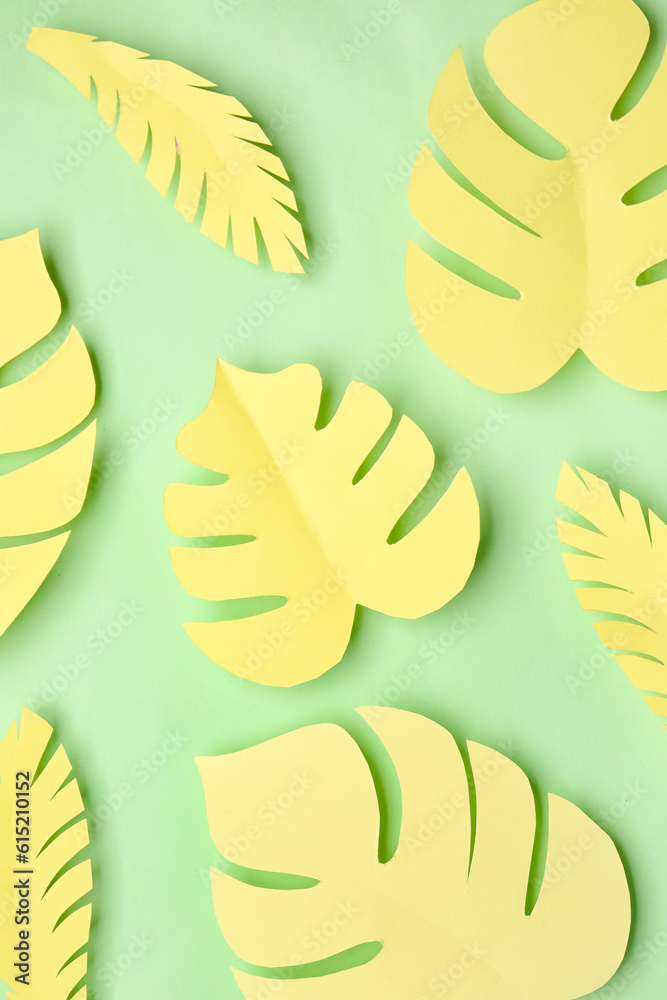 Yellow paper tropical leaves on green background