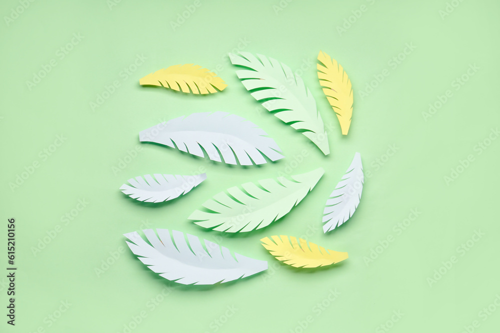 Paper tropical leaves on green background