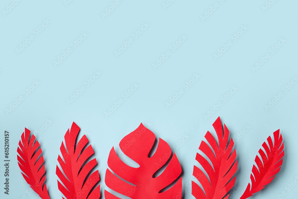 Red paper tropical leaves on blue background