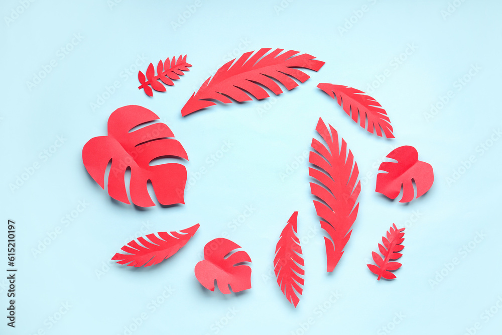 Frame made of red paper tropical leaves on blue background