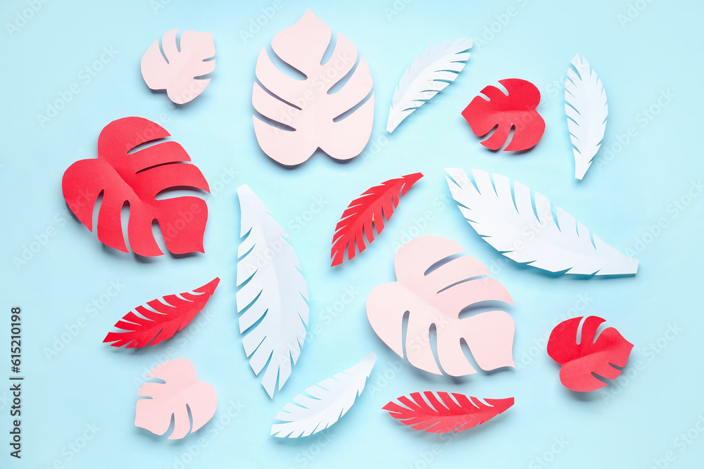 Paper tropical leaves on blue background