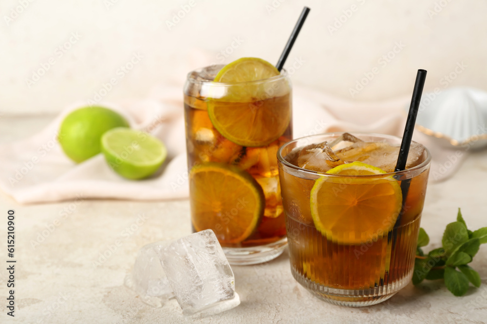 Glasses of tasty Cuba Libre cocktail on light background