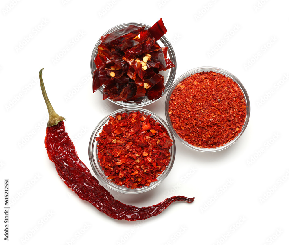 Bowls of ground and sliced chili with dry hot pepper on white background