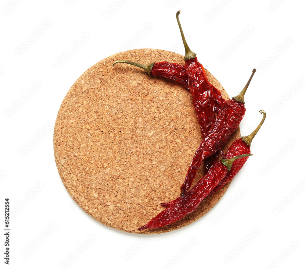 Wooden coaster with dry hot chili peppers on white background