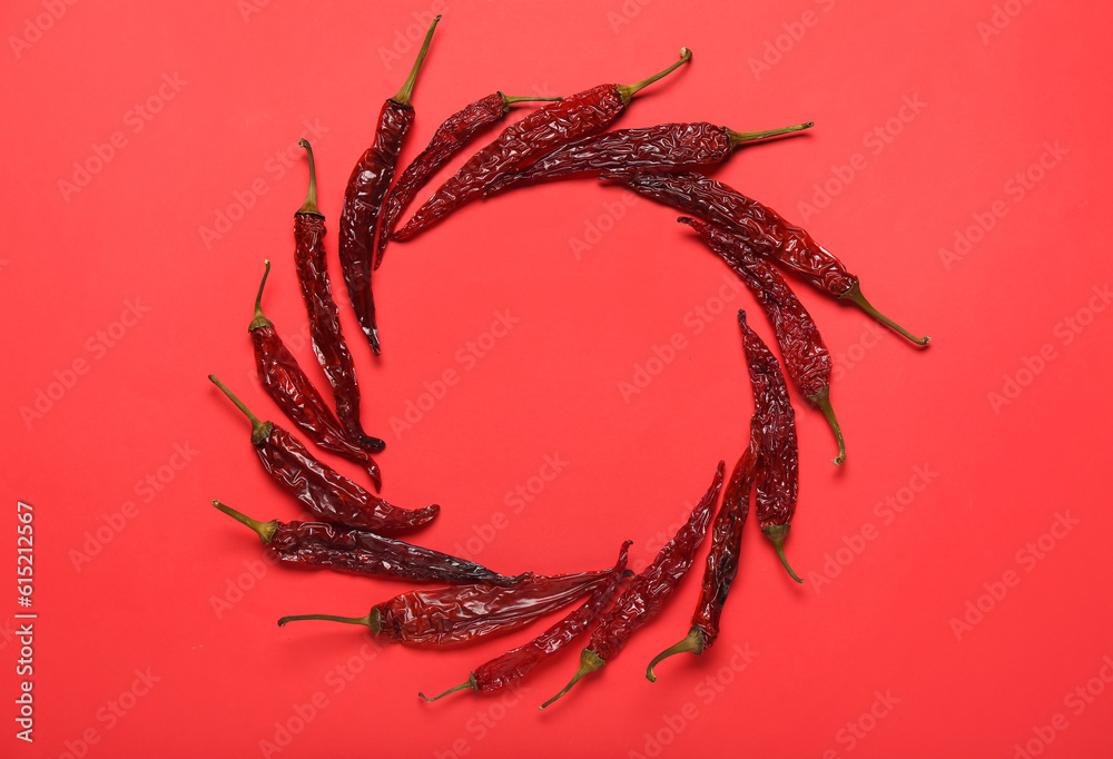 Frame made of dry chili peppers on red background