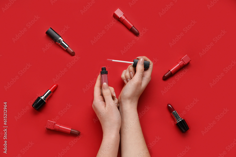 Woman with lipsticks on red background