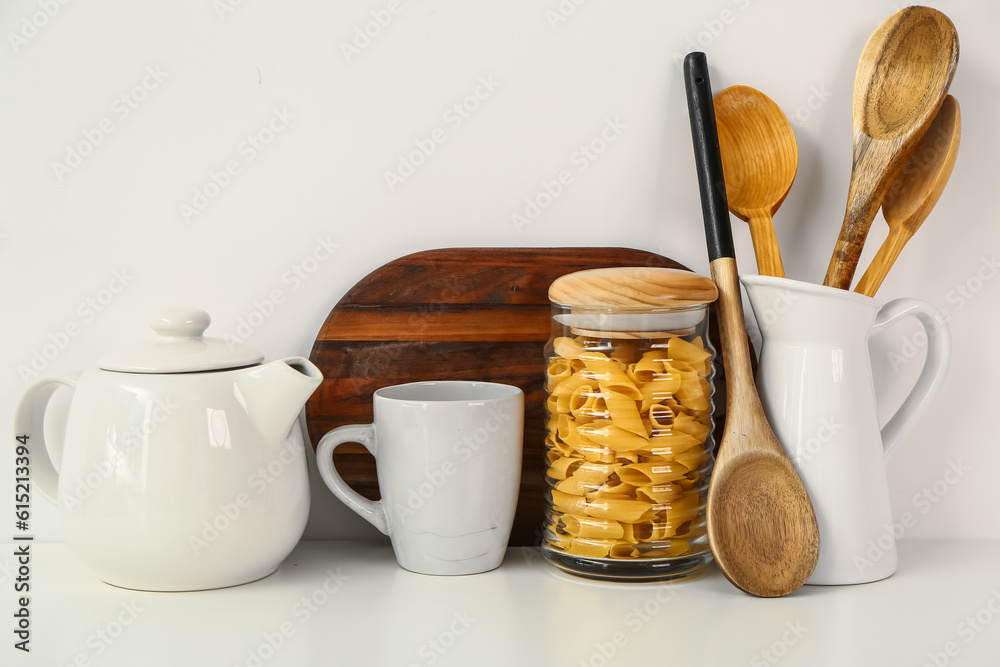 Composition with teapot, cup and different items on white table