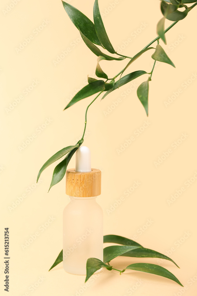 Bottle of cosmetic oil with eucalyptus twigs on beige background