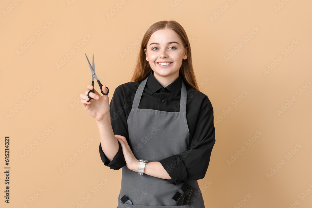 Female hairdresser with scissors on beige background