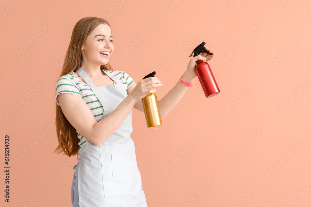 Female hairdresser with sprays on pink background