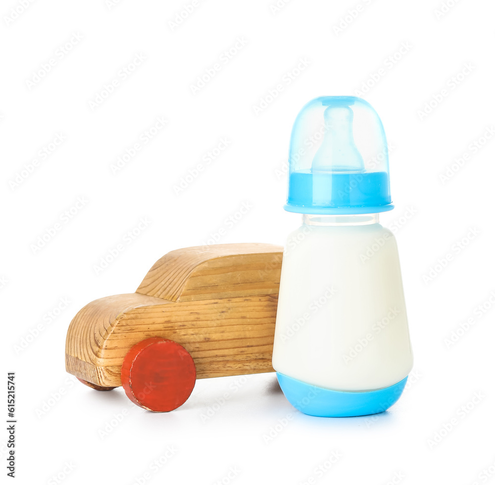 Bottle of milk for baby with wooden toy isolated on white background