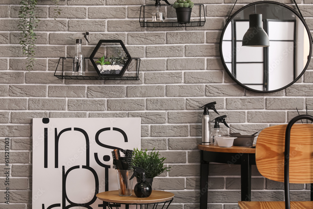 Modern hairdresser workplace near grey brick wall in salon