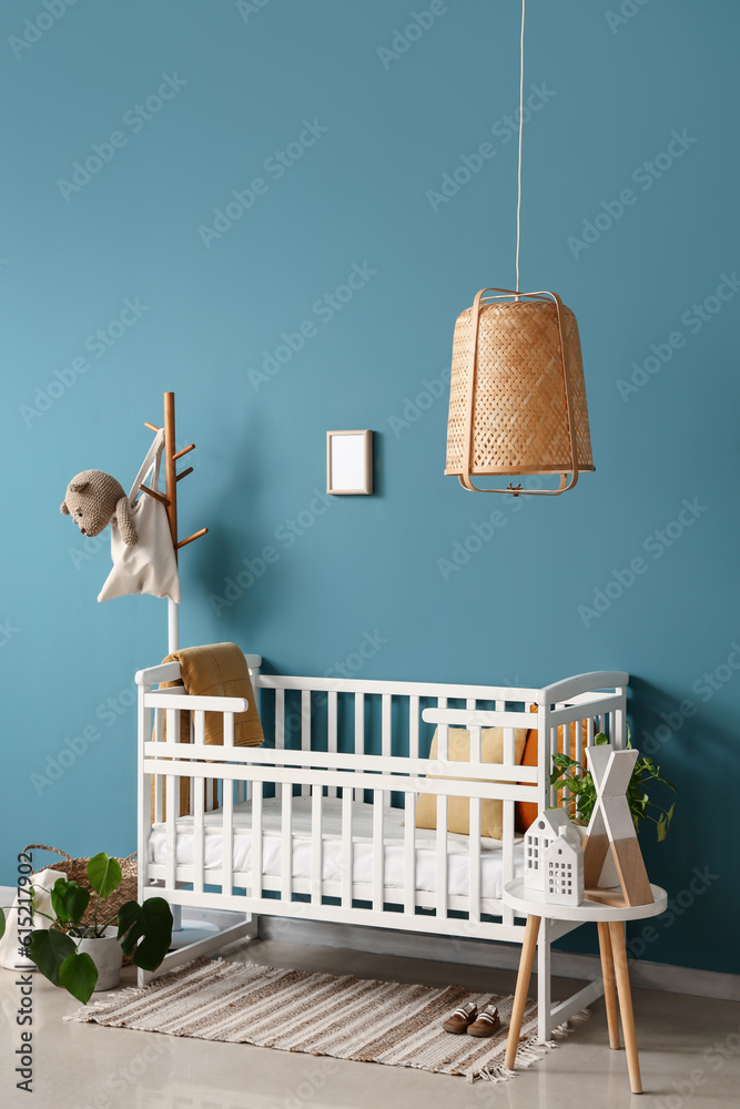 Interior of bedroom with baby crib, rack and table