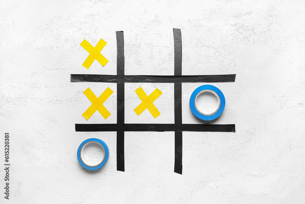 Tic-tac-toe game made of adhesive tapes on white background