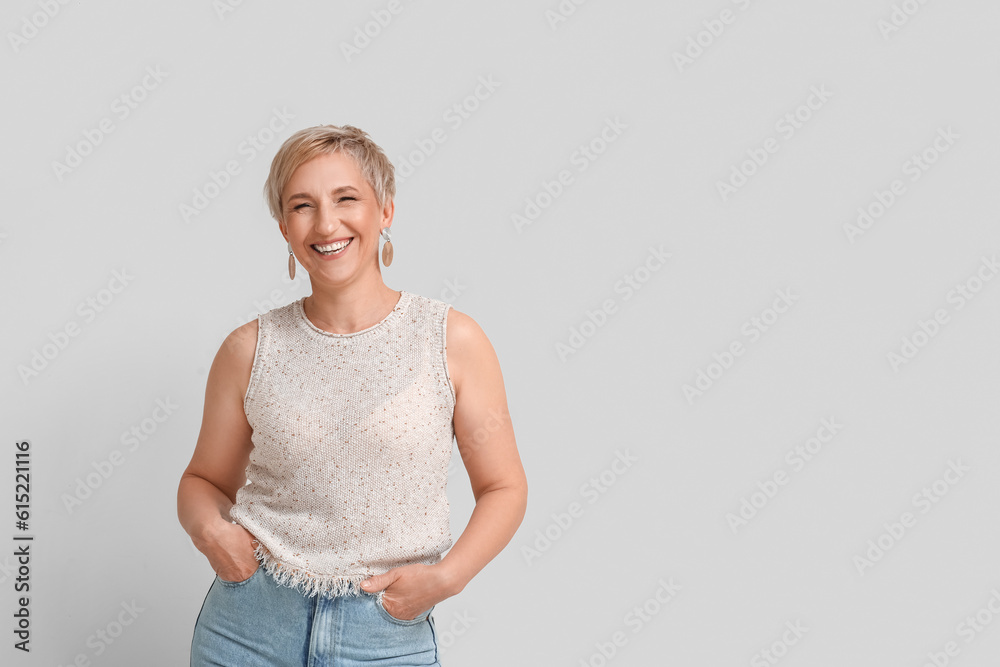 Mature blonde woman on light background