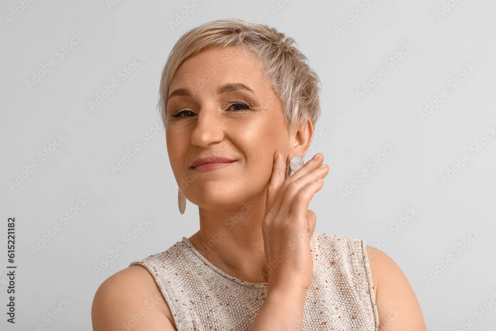 Mature blonde woman on light background, closeup