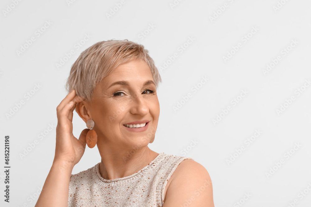 Mature blonde woman on light background, closeup