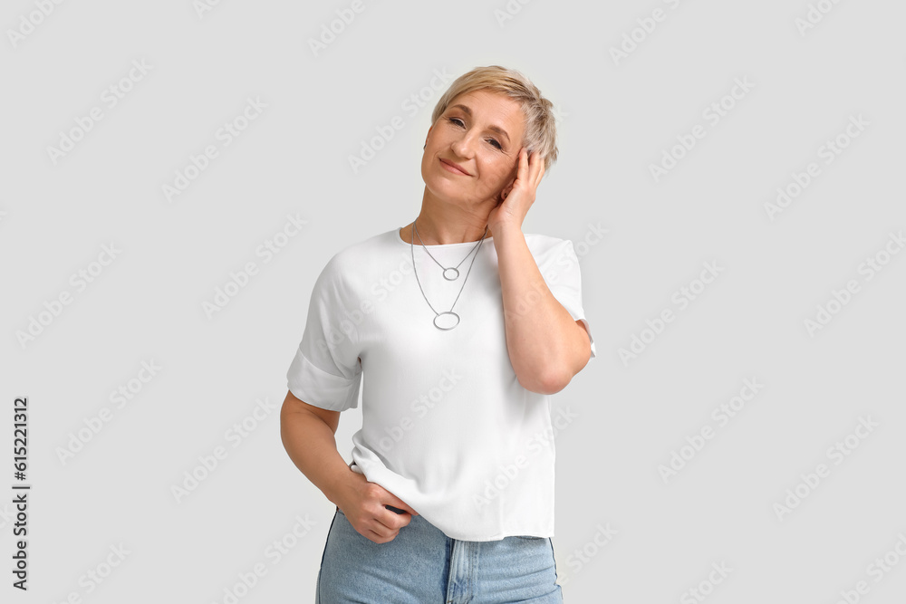 Mature blonde woman on light background