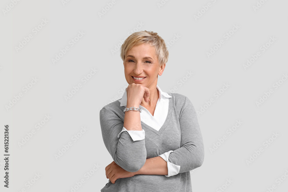 Mature blonde woman on light background