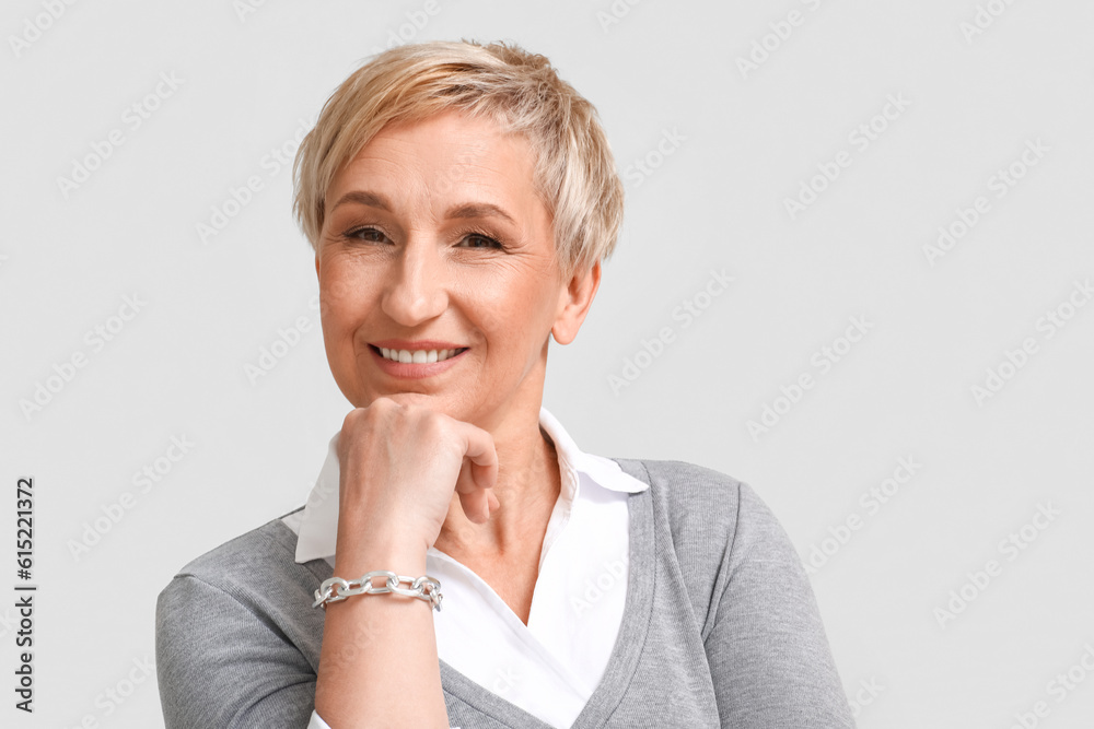 Mature blonde woman on light background, closeup