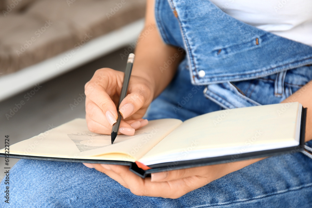 Young female artist drawing sketch in workshop, closeup