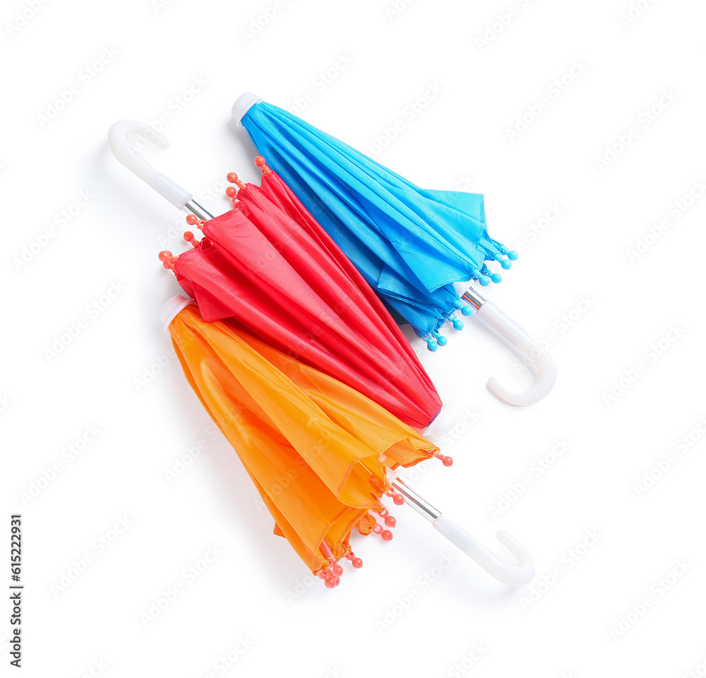 Different mini umbrellas on white background