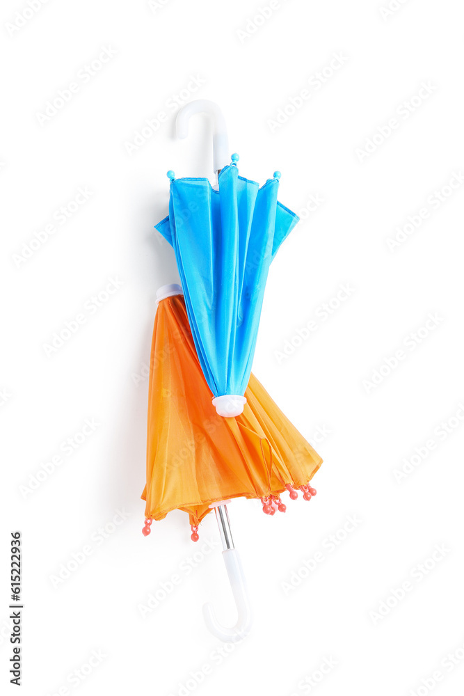 Different mini umbrellas on white background