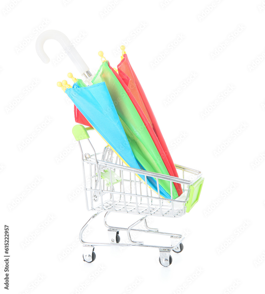 Creative composition with supermarket trolley and mini umbrella on white background